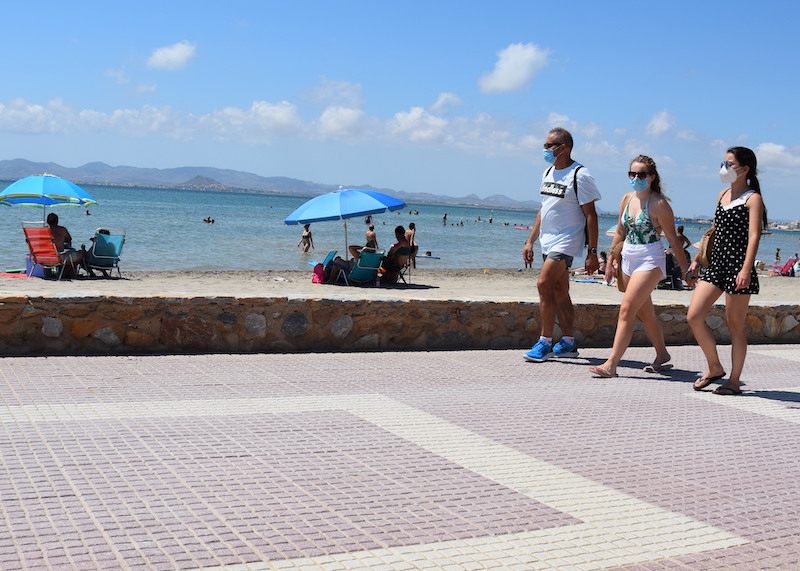 Tres turistas caminan por el paseo marítimo de Los Alcázares con sus mascarillas