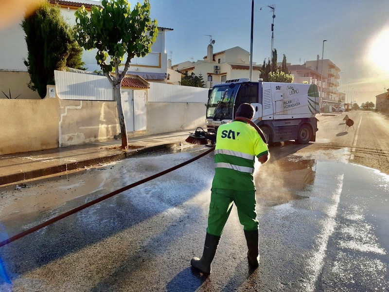 Un operario de limpieza baldea una calle de Pilar de la Horadada