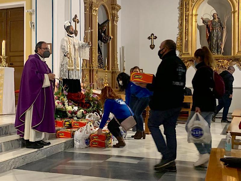 Los vecinos depositan las flores y alimentos en el altar de San Francisco Javier