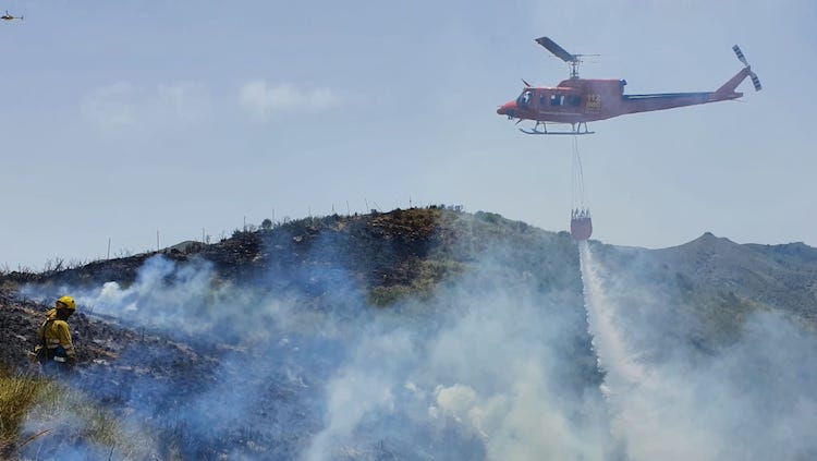 Uno de los helicópteros ayuda en el control del fuego de Fuente Álamo